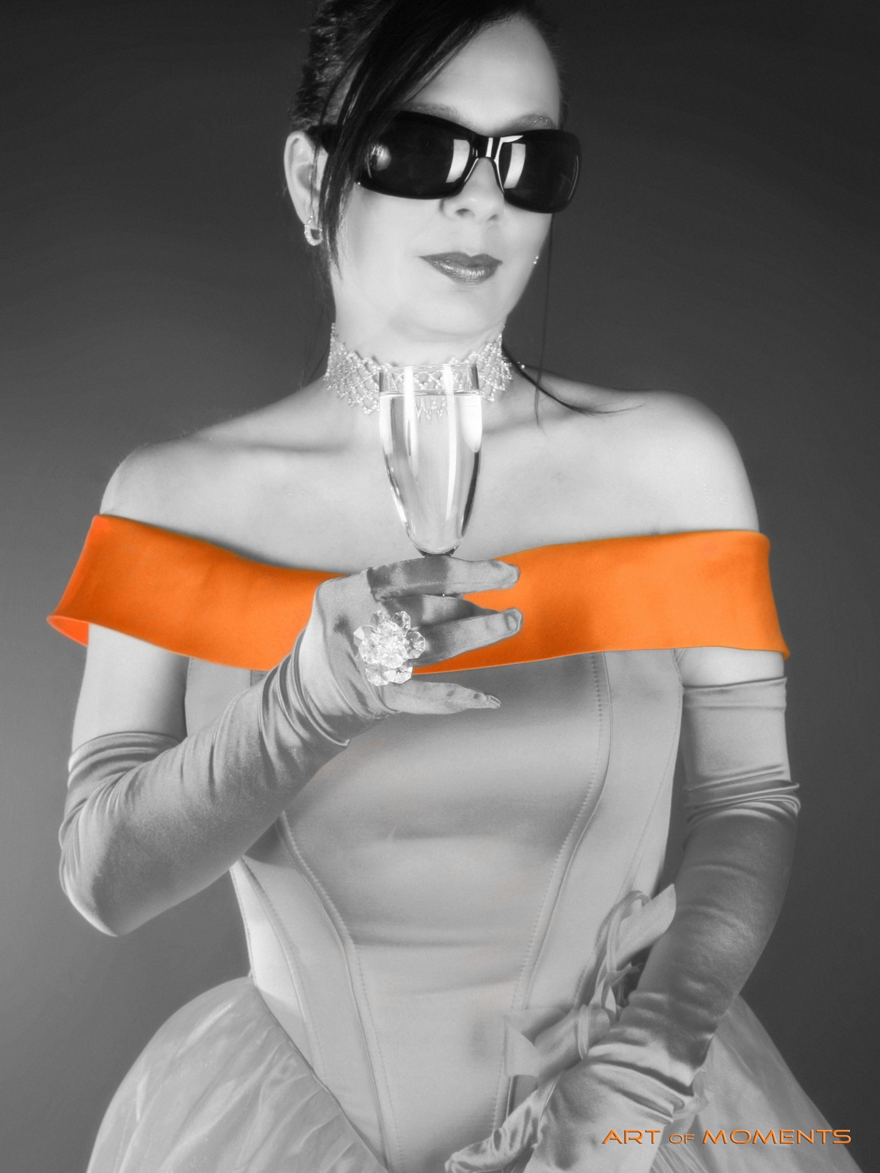 Editoriales Foto einer eleganten Frau mit Sonnenbrille und Sektglas, teilkoloriert